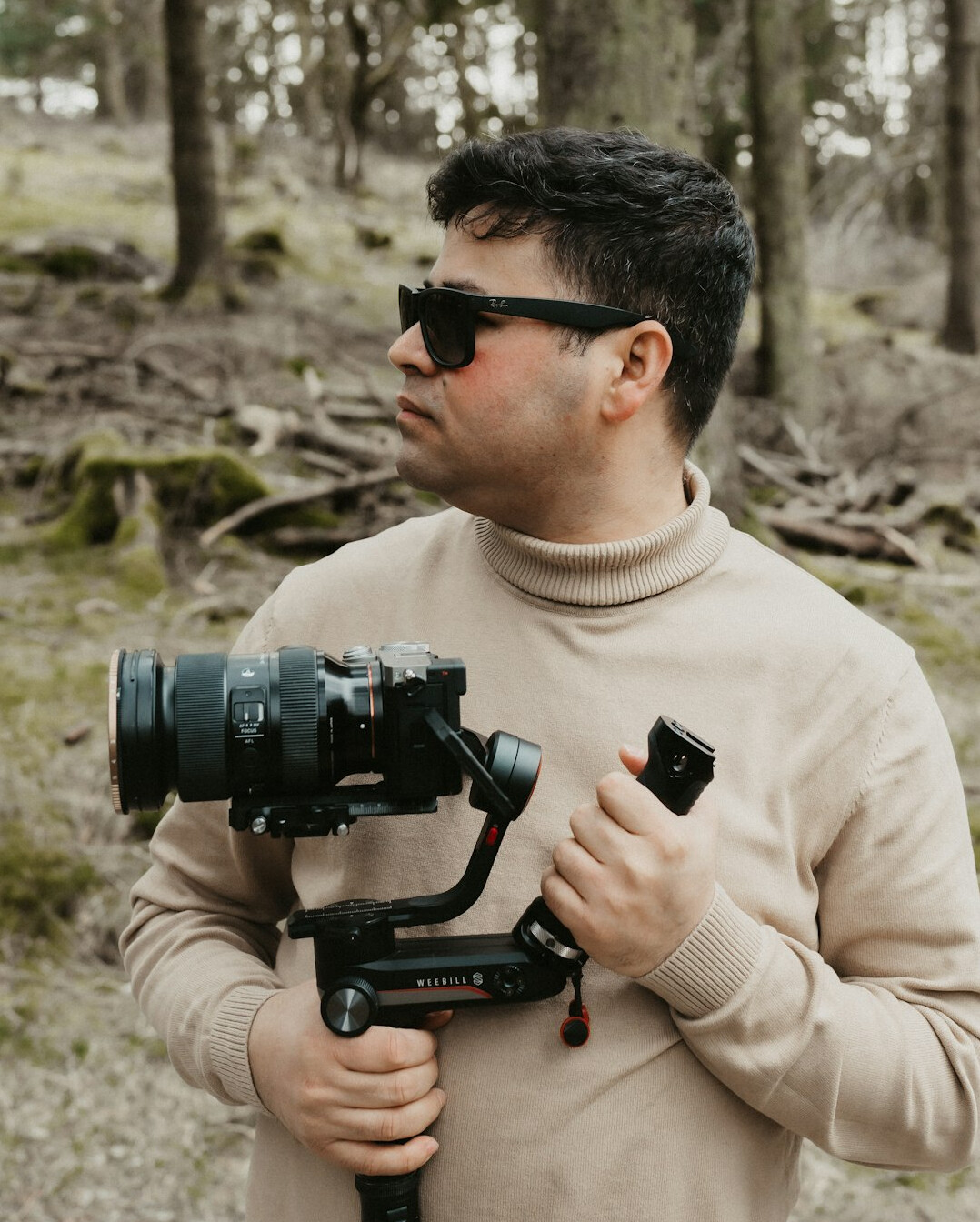 Smiling man camera operator with a professional video camera on his shoulder